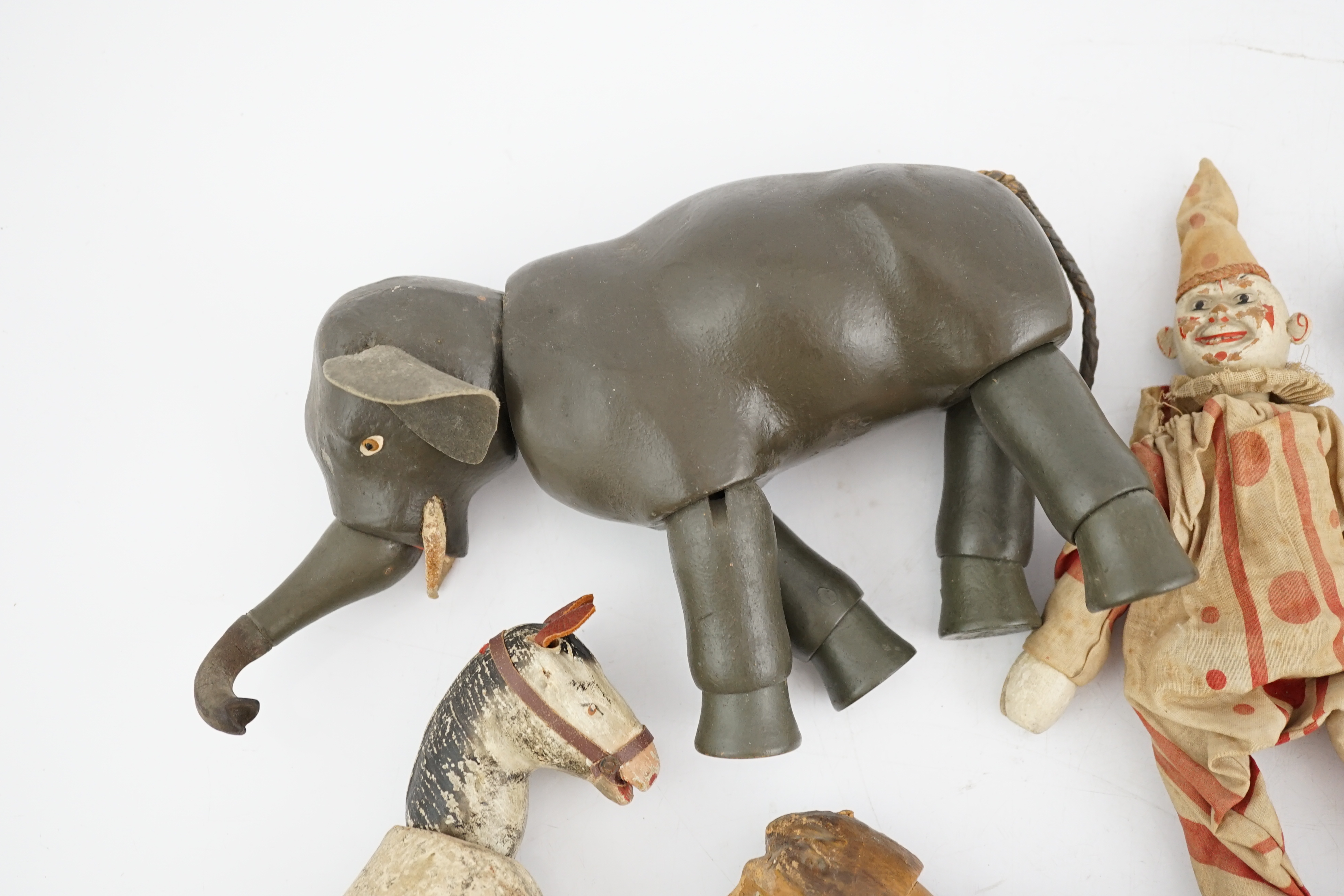 A Schoenhut Humpty Dumpty Circus, early 20th century, including elephant, lion house and other pieces, a playbarn (10) plus a peg doll and a German tinplate clockwork dog